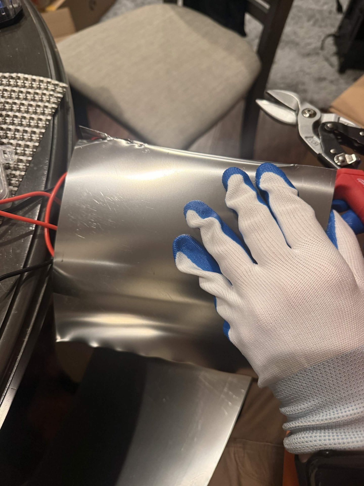Metal sheet being cut with snips during controller fabrication